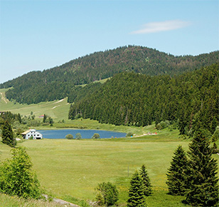 Photographie d'un paysage jurassien avec la forêt et un lac